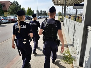 czworo policjantów - policjant i trzy kursantki idą chodnikiem w stronę przejścia podziemnego przy dworcu PKP