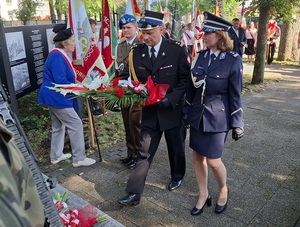 przedstawiciel wojska, straży pożarnej i policji składają kwiaty pod pomnikiem zesłańców sybiru