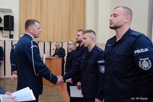 W auli Szkoły Policji w Słupsku Komendant wręcza dyplomy stojącym w rzędzie policjantom