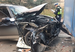 policjant ruchu drogowego sporządza raport z oględzin uszkodzonego porsche