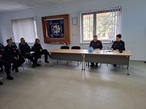 w auli lęborskiej komendy Policji przy stole siedzą prowadzący odprawę Komendant Powiatowy Policji w Lęborku oraz Zastępca Komendanta Wojewódzkiego Policji w Gdańsku