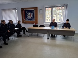 w auli lęborskiej komendy Policji przy stole siedzą prowadzący odprawę Komendant Powiatowy Policji w Lęborku oraz Zastępca Komendanta Wojewódzkiego Policji w Gdańsku