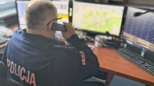 policjant dyżurny na stanowisku kierowania rozmawia przez telefon stacjonarny