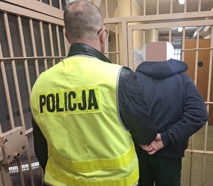 policjant prowadzi zatrzymanego mężczyznę