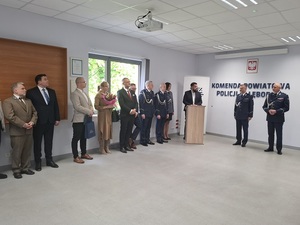 w auli lęborskiej komendy policji przy  mównicy stoi Starosta Lęborski. Obok stoją Komendant Wojewódzki Policji w Gdańsku i Komendant Powiatowy Policji w Lęborku. Po drugiej stronie mównicy stoją policjantka i policjant oraz przedstawiciele władz samorządowych i nadleśniczy Nadleśnictwa Lębork