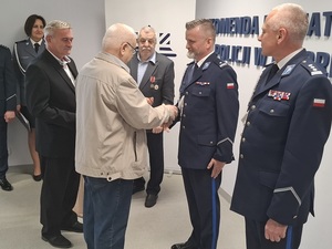 w auli lęborskiej komendy prezesi stowarzyszeń emerytów i rencistów policyjnych ze Słupska i Lęborka wręczają Komendantowi Powiatowemu Policji w Lęborku dyplomy i odznaczenia