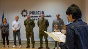 w auli na tle ściany z napisem Komenda Wojewódzka Policji w Gdańsku stoi sześcioro dorosłych osób  dwie dziewczynki bliźniaczki. Przed nimi stoi policjantka z mikrofonem