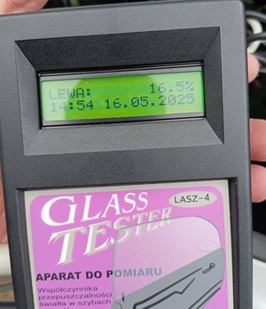 policjant przy radiowozie kontroluje auto, zdjęcie urządzenia do pomiaru