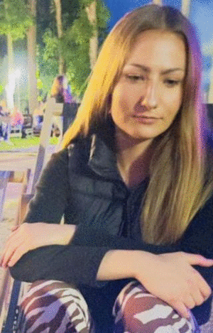zdjęcie młodej dziewczyny siedzącej na leżaku. Ma długie jasne proste włosy, jest ubrana w czarną kamizelkę puchową i czarną bluzkę