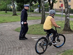 policjanci z młodymi rowerzystami na miasteczku ruchu drogowego