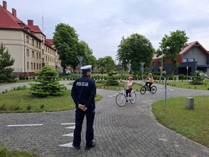 policjanci z młodymi rowerzystami na miasteczku ruchu drogowego