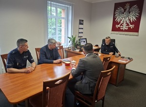 w gabinecie komendanta lęborskiej Policji przy stole siedzą: Komendant, Naczelnik Wydziału Ruchu Drogowego, Starosta Lęborski i pracownik starostwa