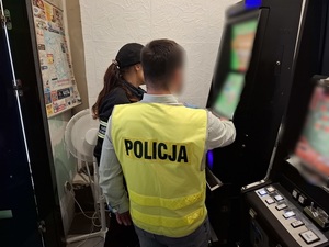 w pomieszczeniu, przed automatem do gier, stoją funkcjonariuszka KAS i nieumundurowany policjant w kamizelce odblaskowej z napisem policja