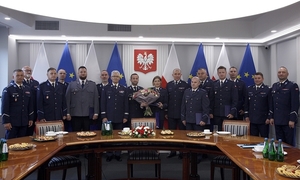 grupowe zdjęcie policjantów na tle godła RP