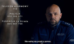 zdjęcie policjanta w stopniu komisarza siedzącego naprzeciw kobiety. Obok numery telefonów pomocowych