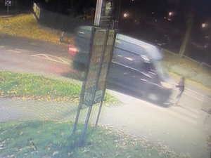 zdjęcie z zapisu monitoringu. Na dworze jest ciemno. Na przejściu dla pieszych znajduje się młoda kobieta, która zwraca się w stronę dostawczego samochodu znajdującego się na pasach tuż przed nią