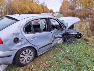 na poboczu znajduje się szary osobowy seat z rozbitym przodem i bokiem