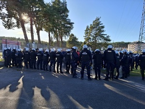 przed wejściem na stadion stoi kilkudziesięciu policjantów ubranych w sprzęt przeciwuderzeniowy. Otaczają kibiców