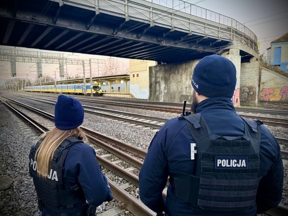 policjantka i policjant służby patrolowej, stojący przy torowisku
