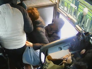 wejście do autobusu. Pierwsza idzie kobieta, za nią mężczyzna z kapturem na głowie
