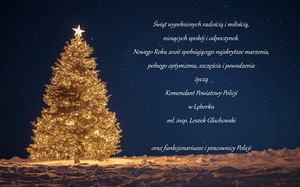 kartka świąteczna z życzeniami na rozgwieżdżonym granatowym niebie. Po lewej stronie rozświetlona choinka