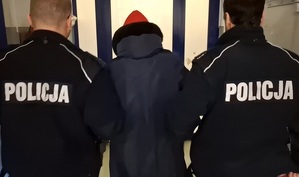 dwaj policjanci prowadzą korytarzem kobietę