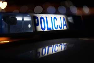 pora nocna. Dach radiowozu z podświetloną tablicą z napisem "policja"