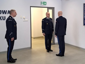 aula lęborskiej komendy Policji. Dowódca uroczystości składa meldunek zastępcy Komendanta Wojewódzkiego Policji w Gdańsku. Obok stoi nowo mianowany p.o. Komendant Powiatowy Policji w Lęborku