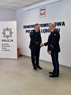 aula lęborskiej komendy Policji. Nowo mianowany p.o. Komendant Powiatowy Policji w Lęborku ściska dłoń zastępcy Komendanta Wojewódzkiego Policji w Gdańsku.