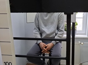 w pomieszczeniu technika kryminalistyki na krześle przed obiektywem aparatu siedzi zatrzymany mężczyzna