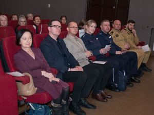 w kinie w pierwszym rzędzie siedzą uczestnicy konferencji, w tym policjant i policjantka