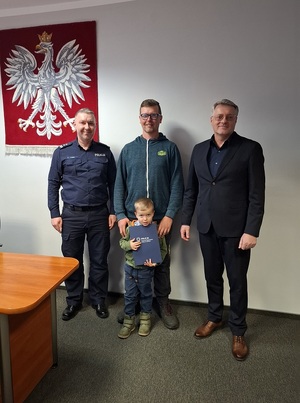 w gabinecie Komendanta Powiatowego Policji w Lęborku stoją obok siebie: komendant, mężczyzna z kilkuletnim chłopcem i zastępca komendanta