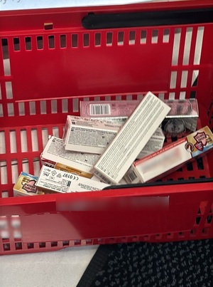 koszyk sklepowy wypełniony opakowaniami kleju do protez zębowych