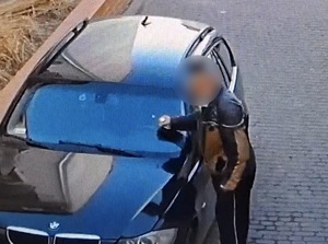 starszy mężczyzna uderza ręką w przednią szybę BMW