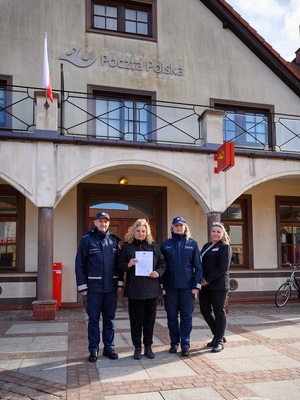 w Łebie przed budynkiem poczty stoją obok siebie komendant policji, listonoszka w cywilnym ubraniu, jej przełożona i policjantka dzielnicowa