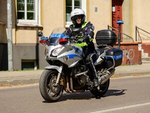 policjantka ruchu drogowego jadąca oznakowanym motocyklem
