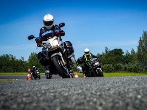 trzej policjanci jadący oznakowanymi policyjnymi motocyklami