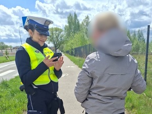 policjantka ruchu drogowego legitymuje rowerzystkę znajdującą się na drodze dla rowerów