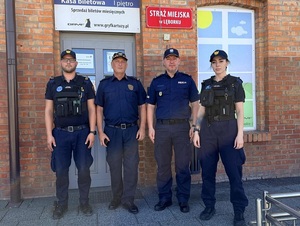 przed budynkiem straży miejskiej w Lęborku stoją komendant policji i komendant straży miejskiej oraz strażnik i strażniczka