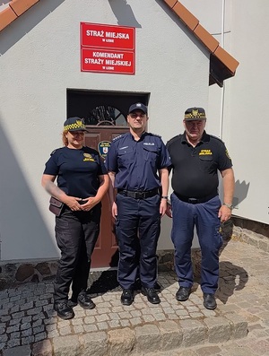 przed budynkiem straży miejskiej w Łebie stoją komendant komisariatu Policji, komendant Straży Miejskiej i strażniczka