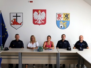 w sali Urzędu Miejskiego w Łebie przy stole siedzą  obok siebie trzej policjanci, Burmistrzyni Łeby i pracownica Urzędu