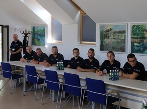 w sali Urzędu Miejskiego w Łebie przy stole siedzi obok siebie siedmioro policjantów. Ósmy policjant stoi obok