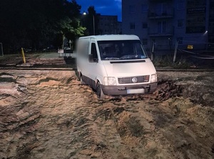 Pora nocna. Biały VW LT unieruchomiony na grząskim terenie przy torowisku