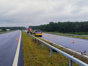 droga S6. Miejsce zdarzenia drogowego. Na pasie ruchu przy barierach ochronnych znajduje się Renault Kangoo. Na jezdni za tym samochodem leżą oderwane od niego części. Przed Renault stoi policyjny radiowóz, przed radiowozem wóz straży pożarnej. Przy pojazdach stoi policjant i strażak.