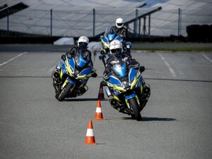 trzej policjanci na motocyklach, pokonujący slalom na torze wyścigowym