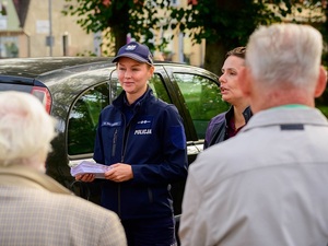 na dworze przed seniorami stoi policjantka