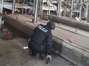 przy taśmie produkcyjnej kuca policyjny pirotechnik